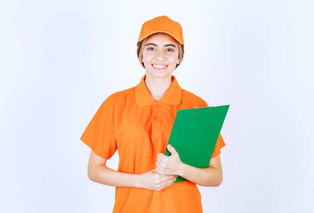 Vrouwelijke koerier in oranje uniform met een groene klantenlijst