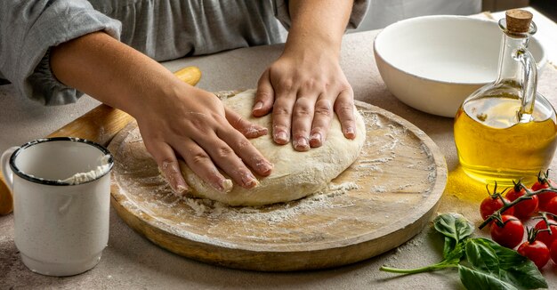 Vrouwelijke kok die pizzadeeg voorbereidt