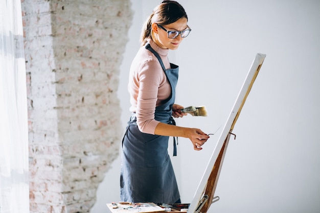 Gratis foto vrouwelijke kunstenaar schilderij in studio