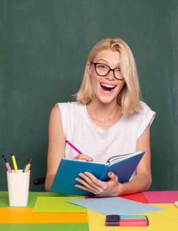 Vrouwelijke leraar glimlachend en lesgevend in de klas op school of universiteit gelukkige vrouwelijke student onderwijzen en leren onderwijs en scholingsconcept