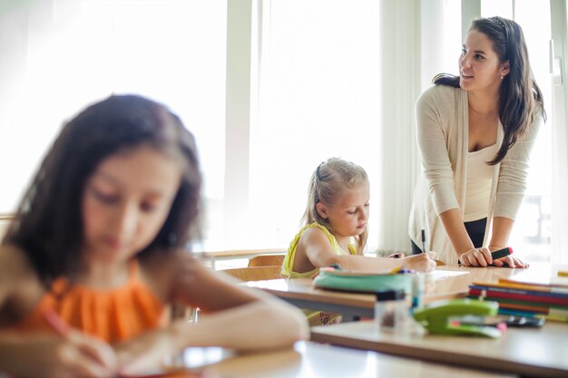 Vrouwelijke leraar leunend op tafel wegkijken