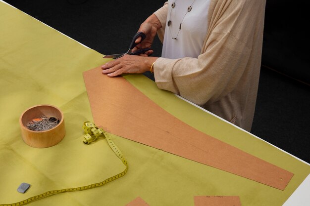 Vrouwelijke modeontwerper in de studio bezig met kleding