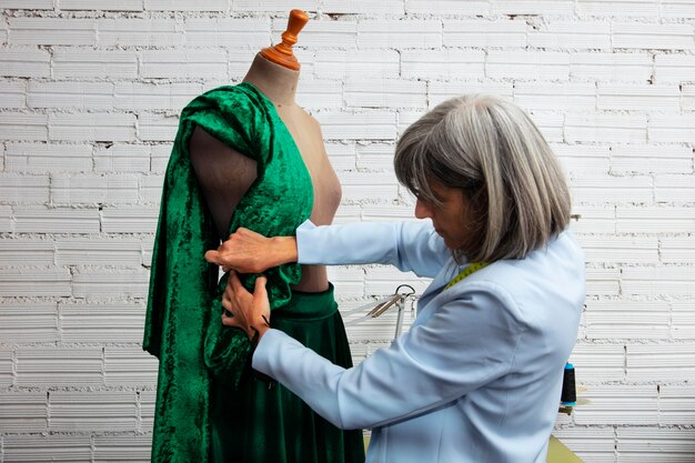 Vrouwelijke modeontwerper in de studio bezig met kleding