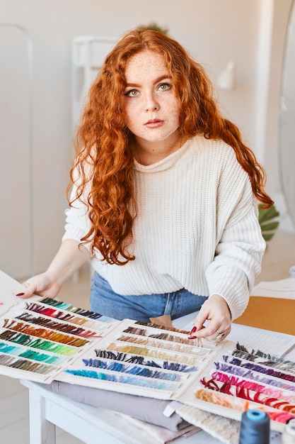 Vrouwelijke modeontwerper werken in atelier met kleurenpalet