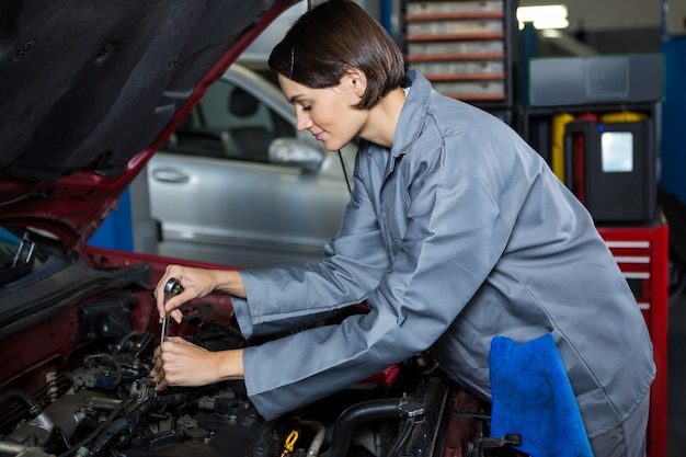 Gratis foto vrouwelijke monteur onderhoud auto