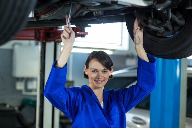 Vrouwelijke monteur onderzoekt autowiel schijfrem