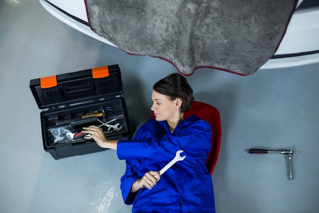 Gratis foto vrouwelijke monteur verwijderen tool van gereedschapskist