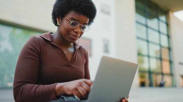 Vrouwelijke ondernemer die buiten op laptop werkt Afro-Amerikaans