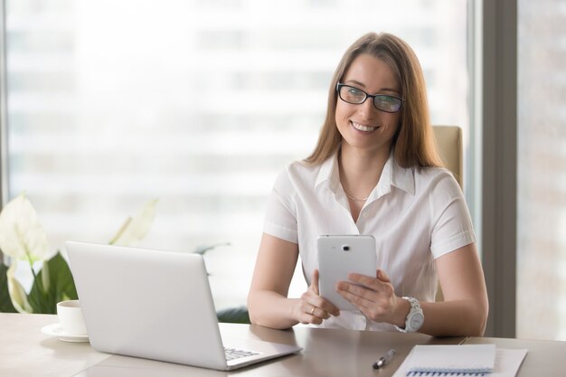 Vrouwelijke ondernemer die digitale tablet in bureau gebruiken