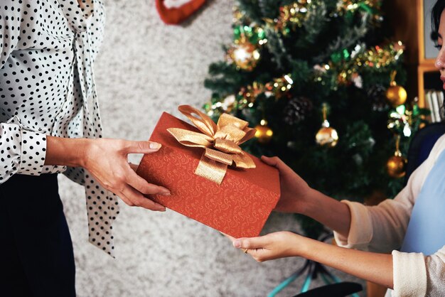 Vrouwelijke ondernemer geven kerstcadeautje haar werknemer