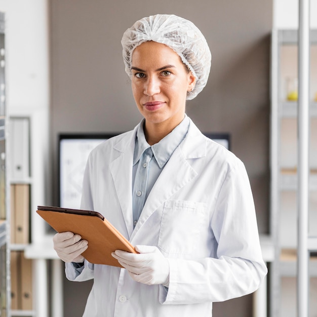 Vrouwelijke onderzoeker in het biotechnologie laboratorium met tablet