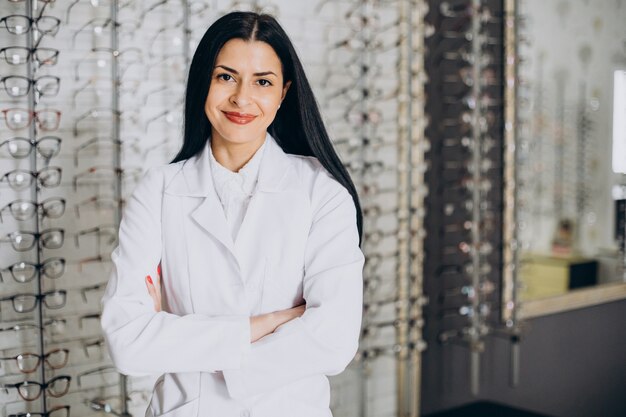 Vrouwelijke oogarts die een bril demonstreert in de opticienwinkel