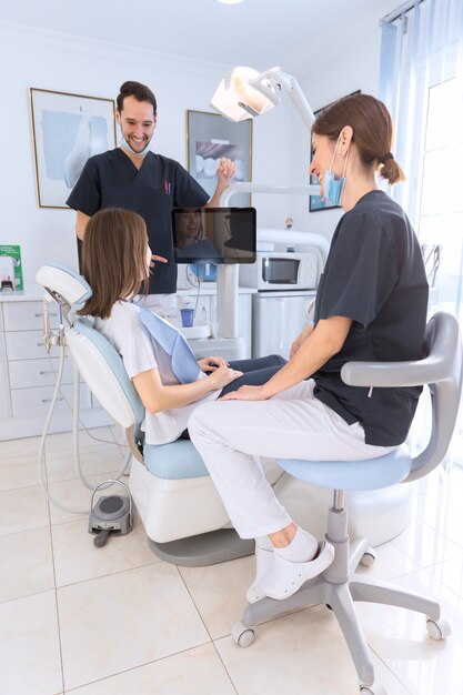 Vrouwelijke patiënt en tandarts hebben een gesprek in de tandheelkundige kliniek
