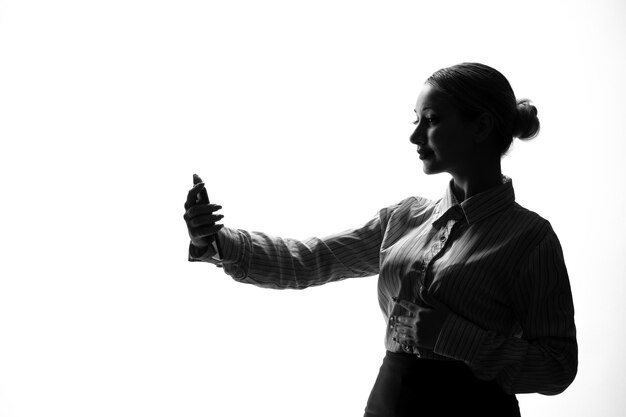 Vrouwelijke persoon silhouet nemen selfie schaduw terug verlichte witte achtergrond young