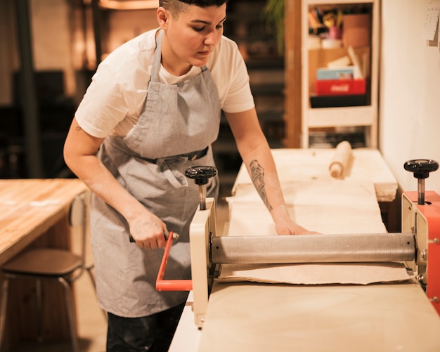 Gratis foto vrouwelijke pottenbakker die in de workshop werkt