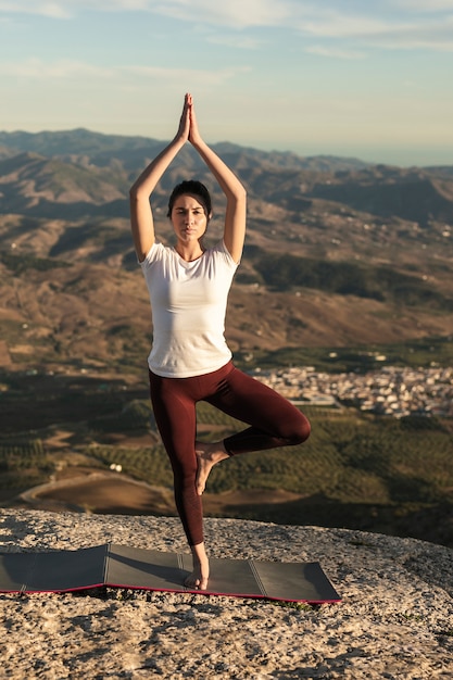 Gratis foto vrouwelijke praktizerende yoga pose met evenwicht