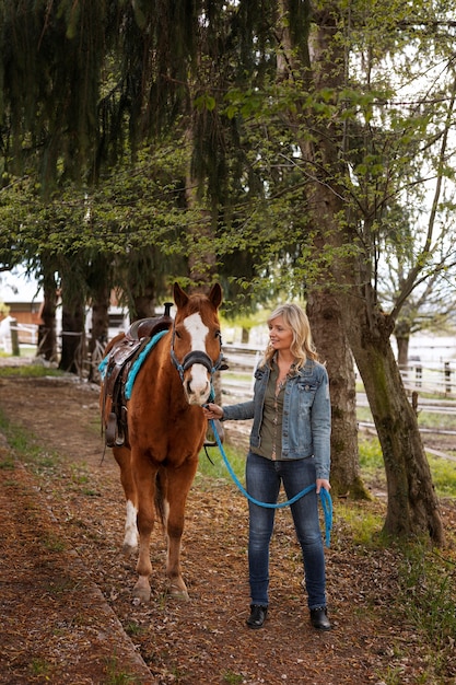 Gratis foto vrouwelijke ruiterinstructeur met paard