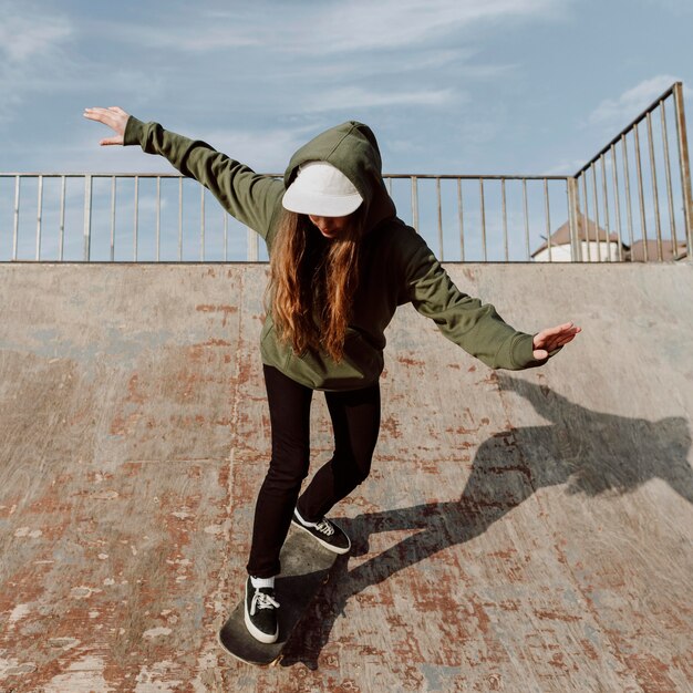 Vrouwelijke skateboarder met hellingen voor trucs