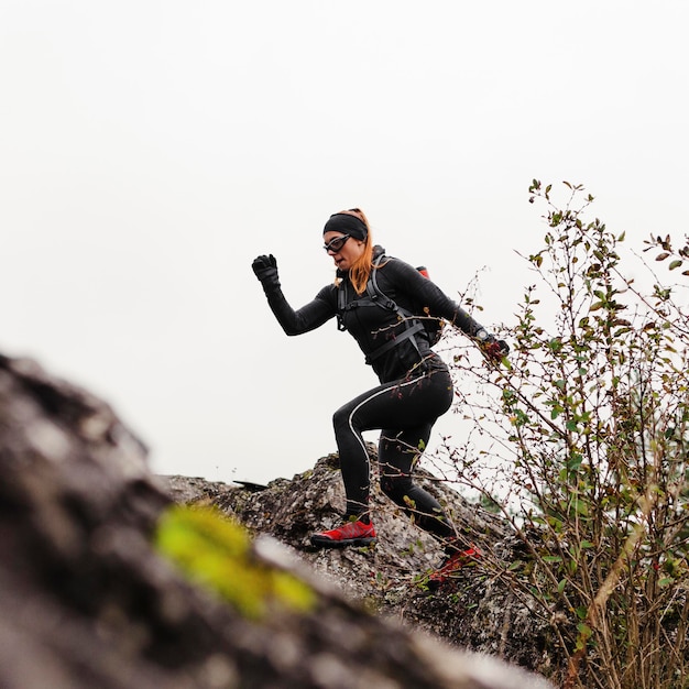 Vrouwelijke sportieve jogger die op stenen loopt