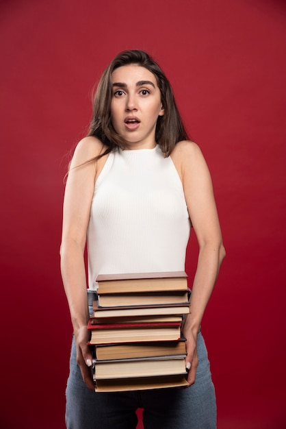 Vrouwelijke student met veel boeken