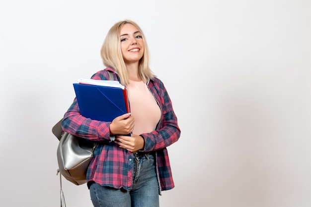 vrouwelijke student met verschillende bestanden met een glimlach op wit