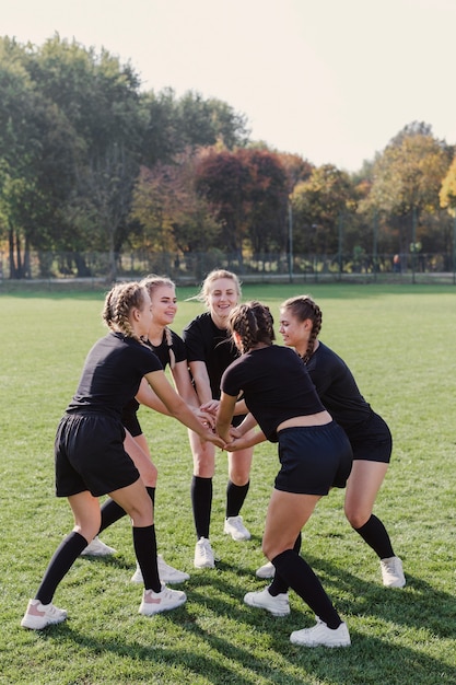 Vrouwelijke teammeisjes die handen samenbrengen