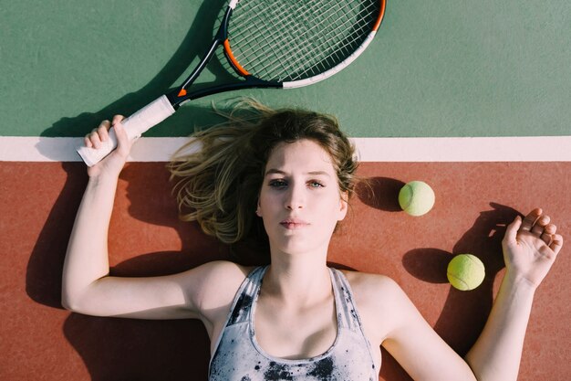 Vrouwelijke tennisspeler die op de grond koelt