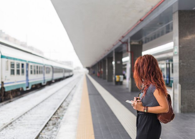 Vrouwelijke toerist die op trein wacht