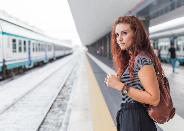 Gratis foto vrouwelijke toerist die op trein wacht