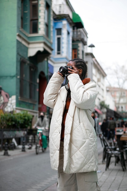 Gratis foto vrouwelijke toeristenfotograaf buitenshuis met camera