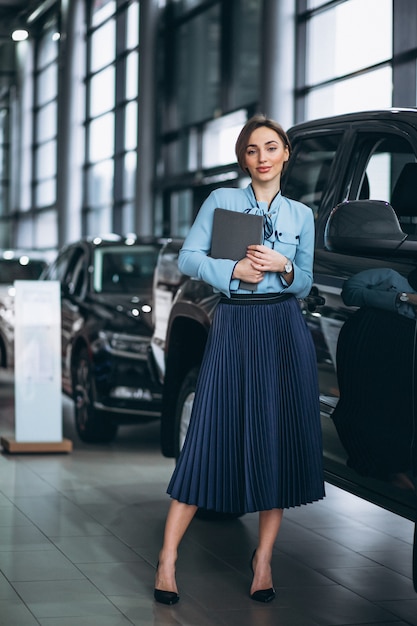 Vrouwelijke verkoper in een autoshowroom