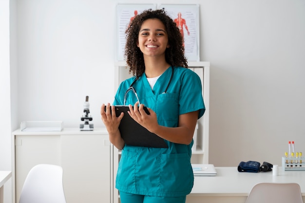 Vrouwelijke verpleegster die geneeskunde oefent in de kliniek