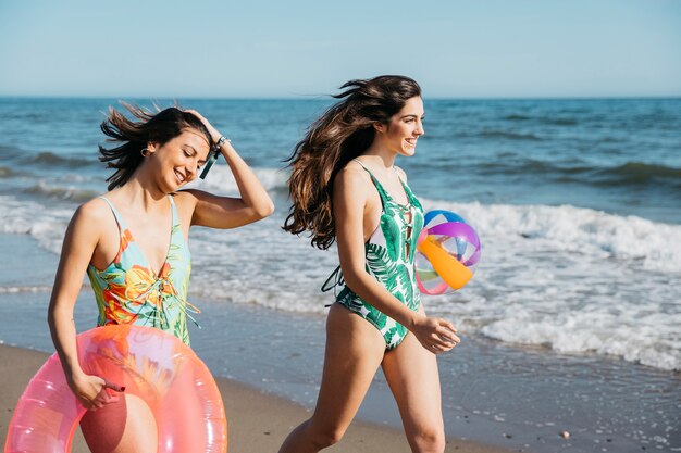 Vrouwelijke vrienden die bij het strand lopen