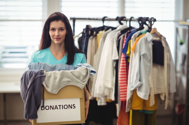 Vrouwelijke Vrijwilligers houden kleren in donatie doos