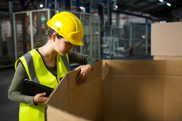 Vrouwelijke werknemer controleren producten in het magazijn