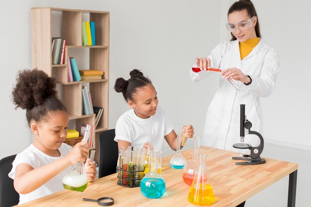 Vrouwelijke wetenschapper die meisjeschemie-experimenten onderwijst