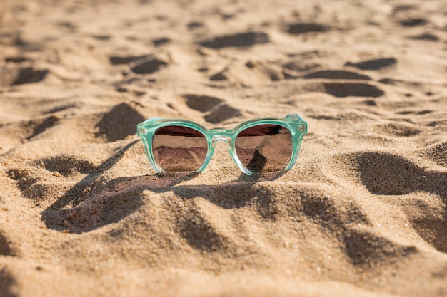 Vrouwelijke zonnebril op zand