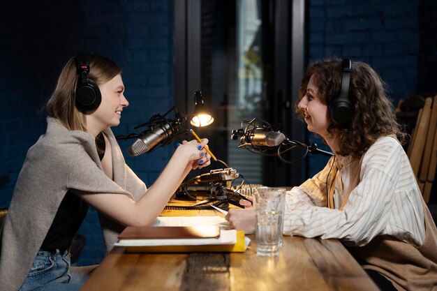 Vrouwen die een podcast draaien terwijl ze een koptelefoon dragen