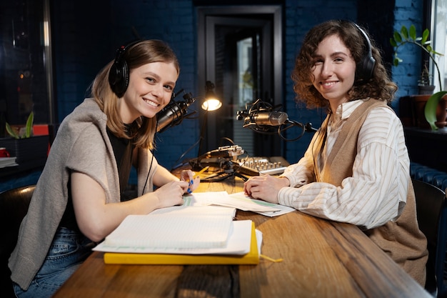 Vrouwen die een podcast draaien terwijl ze een koptelefoon dragen