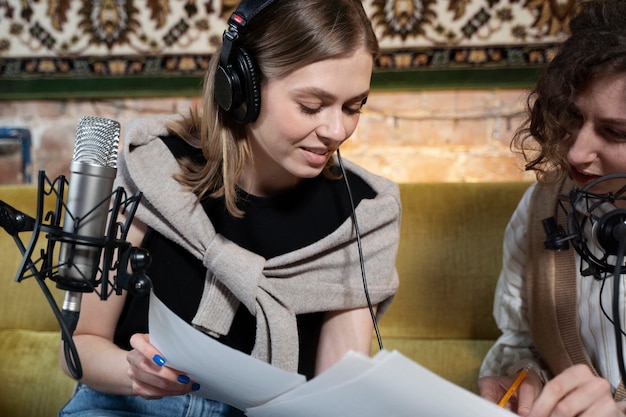 Vrouwen die een podcast draaien terwijl ze een koptelefoon dragen