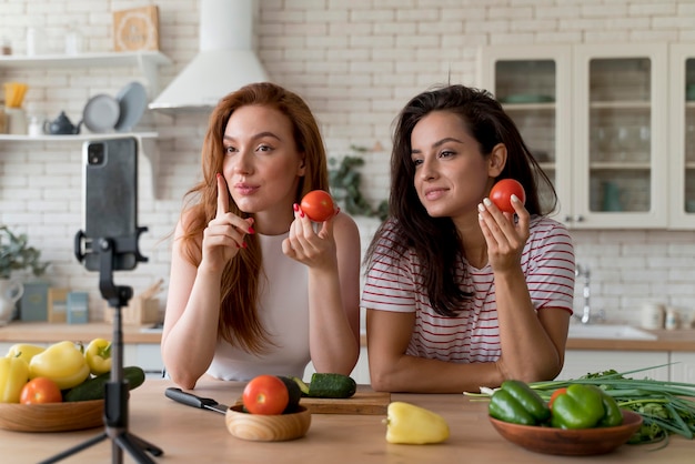 Vrouwen die een vlog maken terwijl ze eten klaarmaken