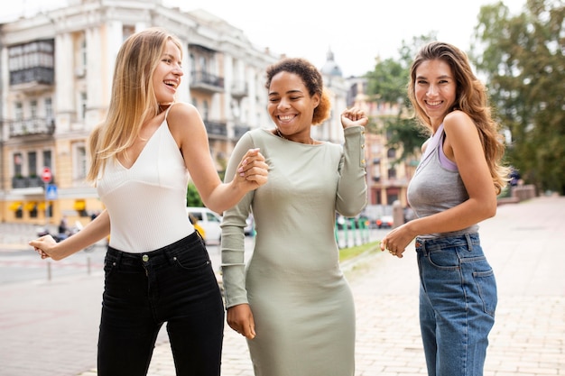 Vrouwen die gelukkig zijn en buiten dansen