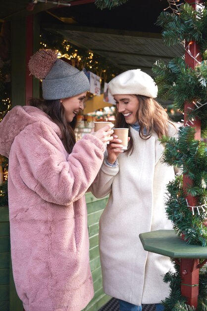Vrouwen die op Kerstmarkt glühwein drinken