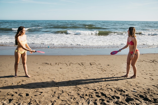 Gratis foto vrouwen die ping pong spelen op het strand