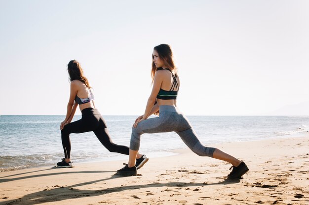 Vrouwen die poten op het strand uitrekken