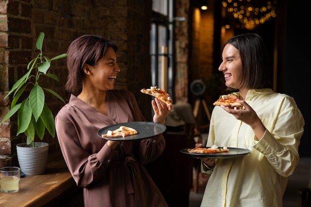 Vrouwen die samen traditionele Italiaanse pizza eten