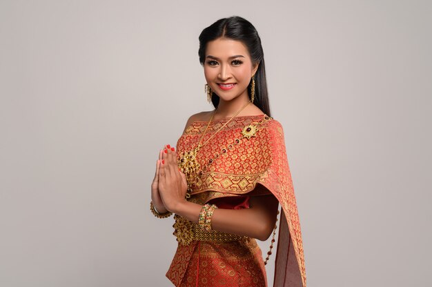 Vrouwen die Thaise kleding dragen die respect respecteren, sawasdee-symbool