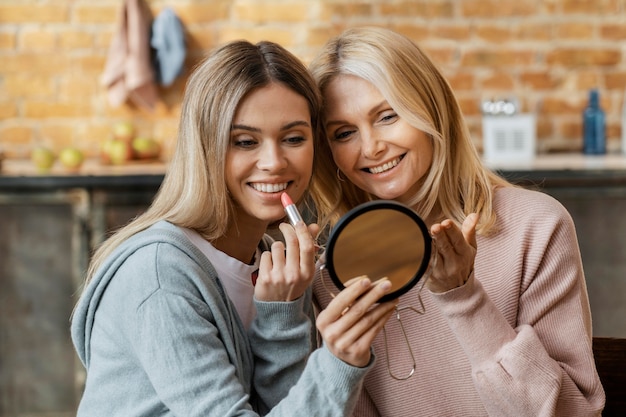 Gratis foto vrouwen die thuis lippenstift samen aanbrengen