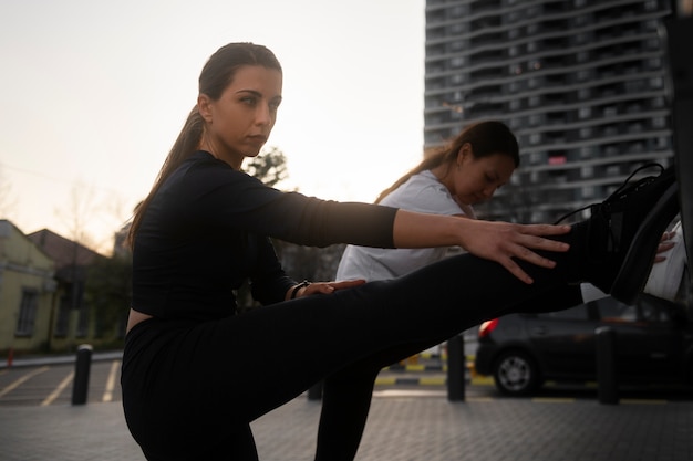 Vrouwen die zich samen uitstrekken voordat ze buiten trainen