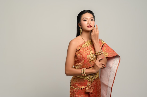 Vrouwen dragen Thaise kleding en handen raken hun gezicht aan